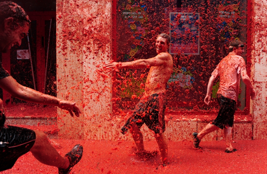 BUNOL, SPAIN - AUGUST 26: Revellers pelt each other with tomatoe pulp during the world's biggest tomato fight at La Tomatina festival on August 26, 2009 in Bunol, Spain. More than 45000 people from all over the world descended on the small Valencian town to participate in this year's La Tomatina festival, with the local town hall estimating that over 100 tons of rotten and over-ripe tomatoes were thrown. (Photo by Jasper Juinen/Getty Images)