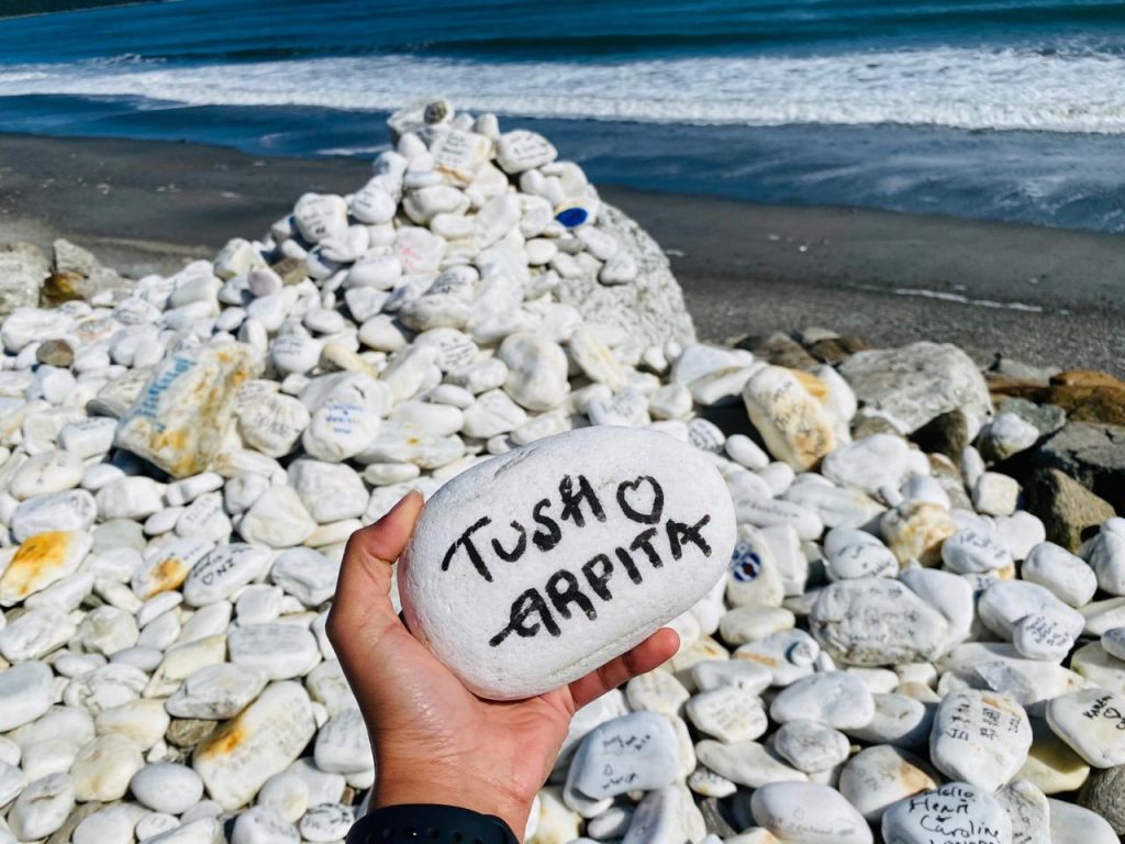 A couple names beautifully written in a white stone on the beach