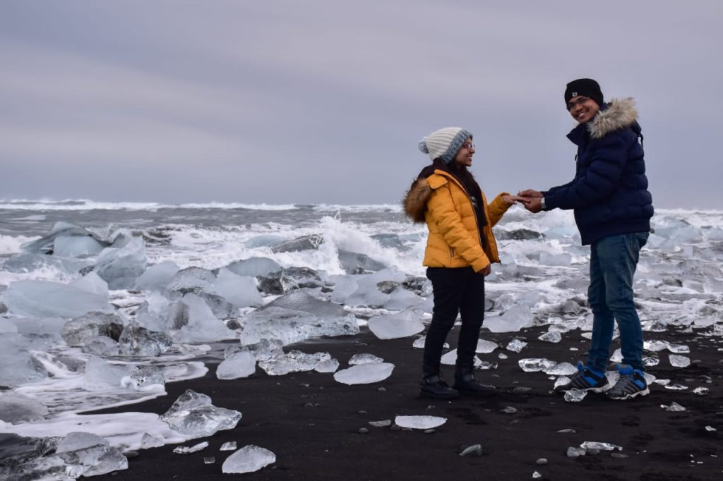 A beautifully captured picture of a couple proposal on the diamond beach in Iceland