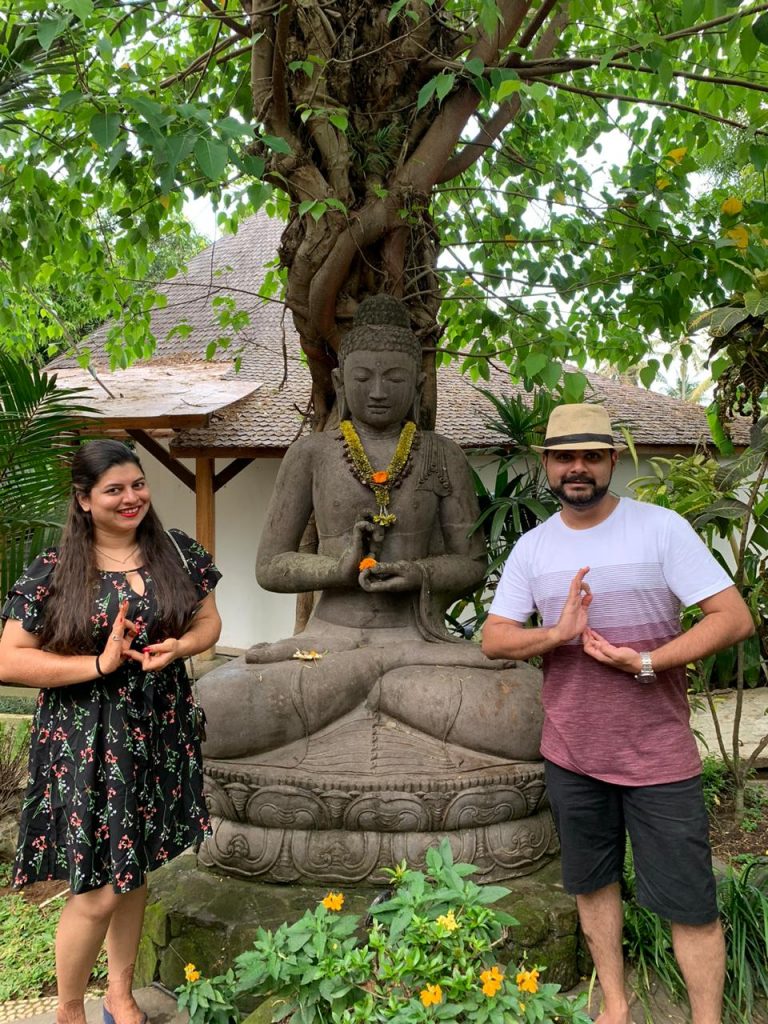 A couple trying to copy the pose of a statue in Bali