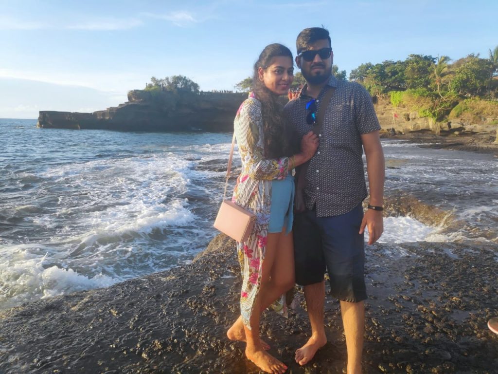 A couple posing with beach as the background