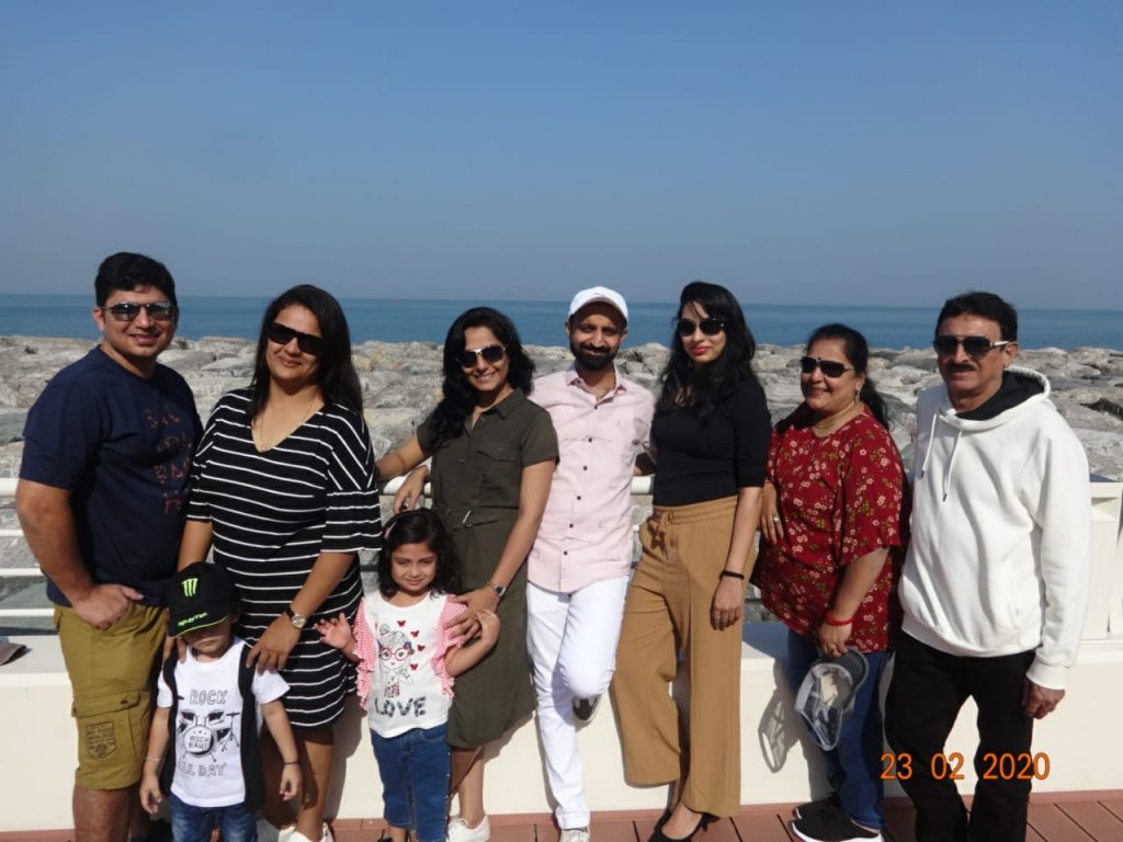 A family posing for a picture with the beach as a backdrop