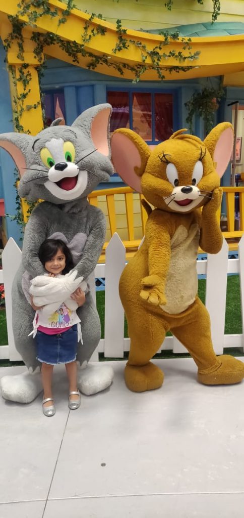 A picture of a cute little kid hugged by a mickey mouse on their family trip to Dubai