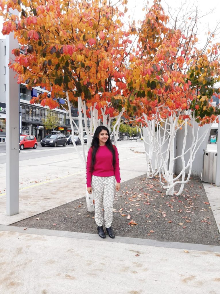 A picture of a woman standing under a picturesque tree