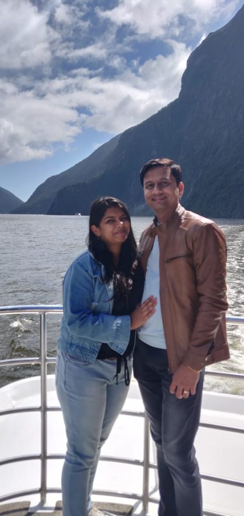 A couple posing for a picture on the cruise on their honeymoon vacation to New Zealand