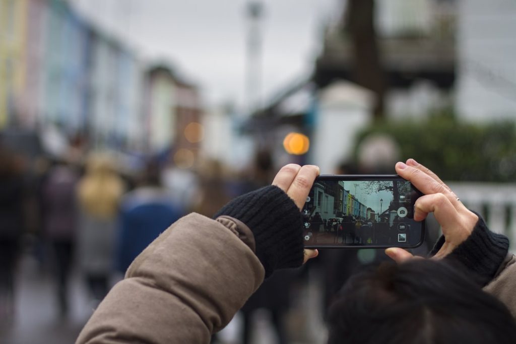 a traveller clicking picture on her phone